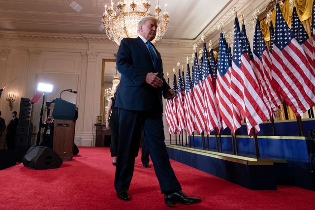 United States President Donald Trump departs after making a statement to the nation as his supporters look on in the East Room of the White House in Washington, DC on election night.